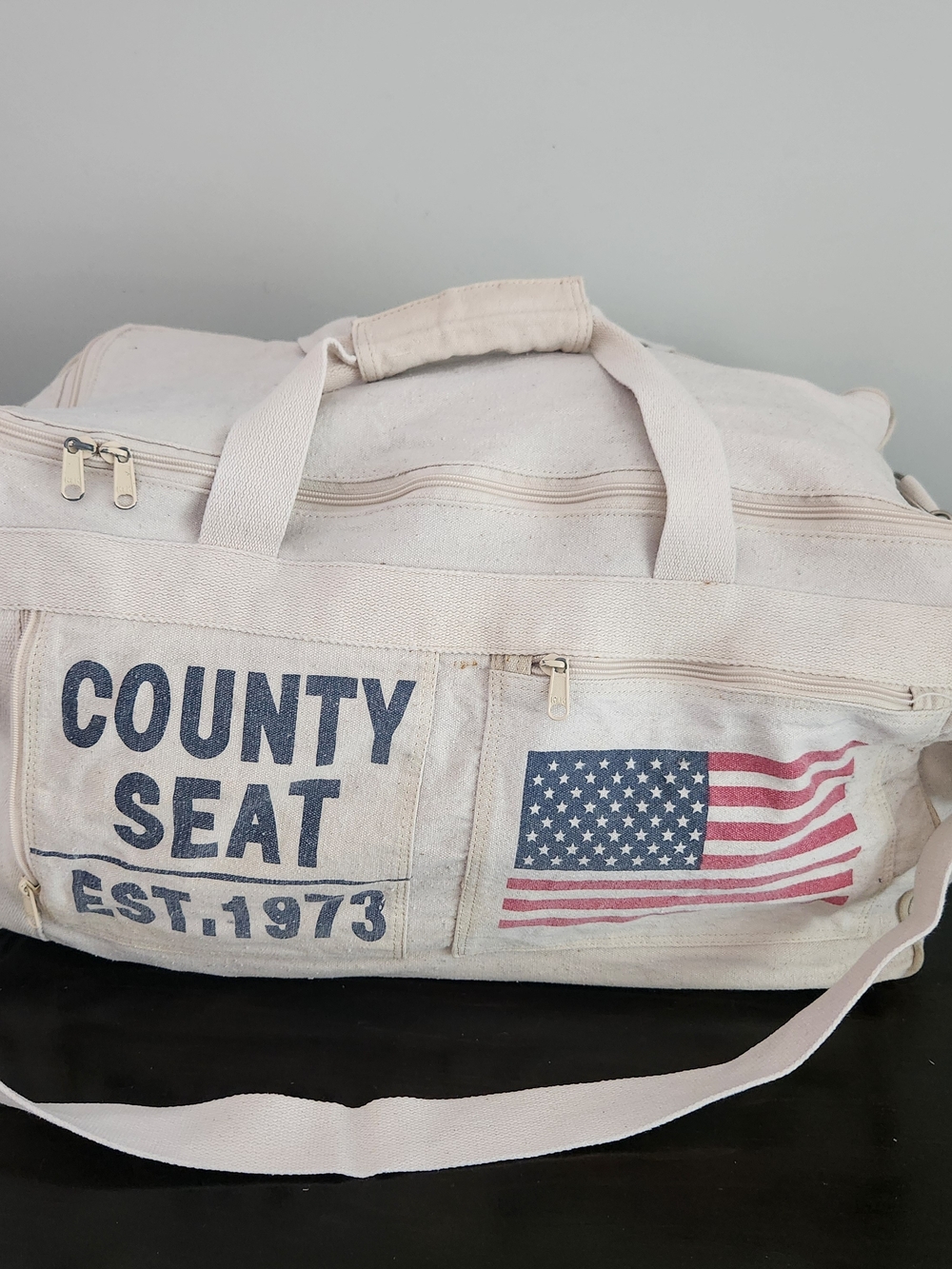 County Seat Off-White Canvas Duffel Bag with American Flag Graphic